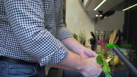 Close up on man's hands peeling and washing radishes. Slider shot. 库存影片 70574717