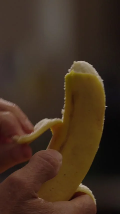 Close-up man's hands peeling a bannana vertical video Stockbeeldmateriaal 286778962