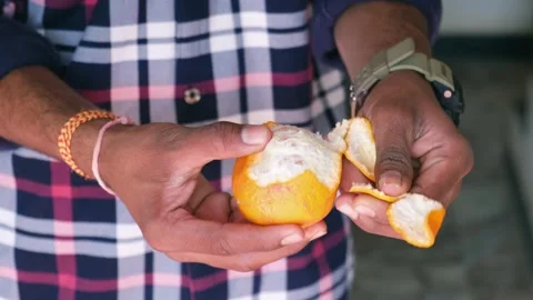 Close-up of a man's hands peeling a fresh orange Stock-Footage 329922093