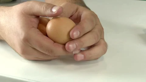 Close-up of a man's hands playing and juggling with two raw eggs Vídeos de archivo 345750248