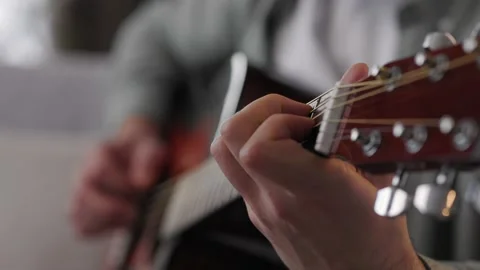 Close-up of a man's hands playing the guitar. Male musician plays an acoustic Stock Footage 183937336