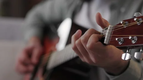 Close-up of a man's hands playing the guitar. Male musician plays an acoustic Stock Footage 209692381