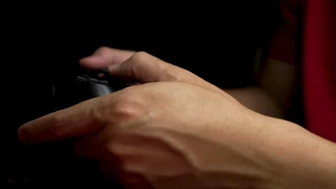 Close-up of man's hands playing video games on game console sitting on sofa 库存影片 334653374