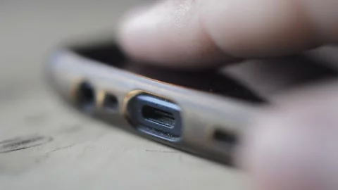 Close-up man's hands plug white charger cable at the phone. phone charge battery 库存影片 200454022