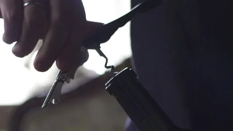 Close-up man's hands pulling a cork out of a wine bottle with a corkscrew. Slow  Stock Footage 153383912