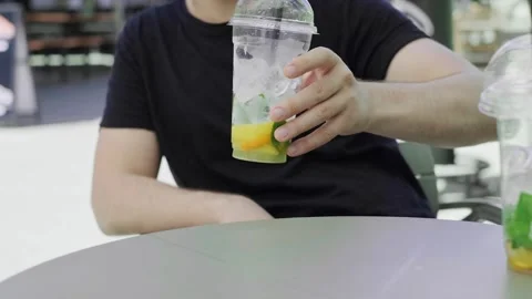 Close-up of a man's hands reaching for a non-alcoholic cocktail on the table, en Stock Footage 279163946