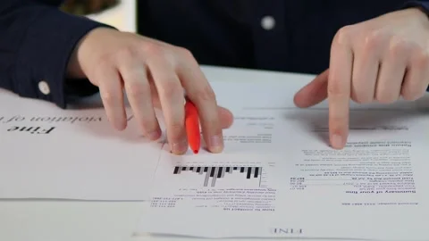 Close-up of a mans hands running his finger over the text of a fine notice Stock Footage 313651455