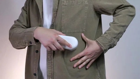 Close-up of a mans hands running a lint remover over a denim shirt he is wearing Video stock 314091720