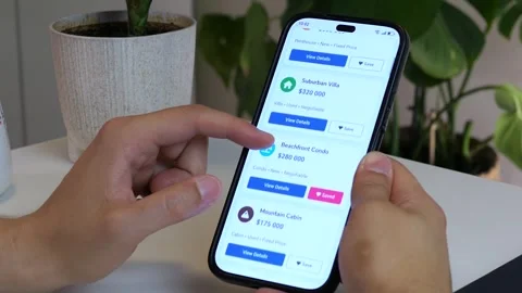 Close-up of a mans hands scrolling through various luxury real estate listings Video stock 315649653