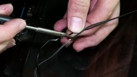 A close-up of a man's hands soldering two wires Video stock 346882058