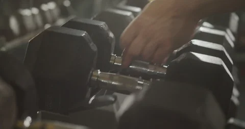 Close-up man's hands take heavy dumbbells in the gym. 4K Slow Motion Video stock 123535860