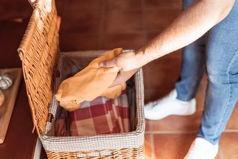 Close-up of a man's hands taking a T-shirt out of the laundry basket. Stock Photos