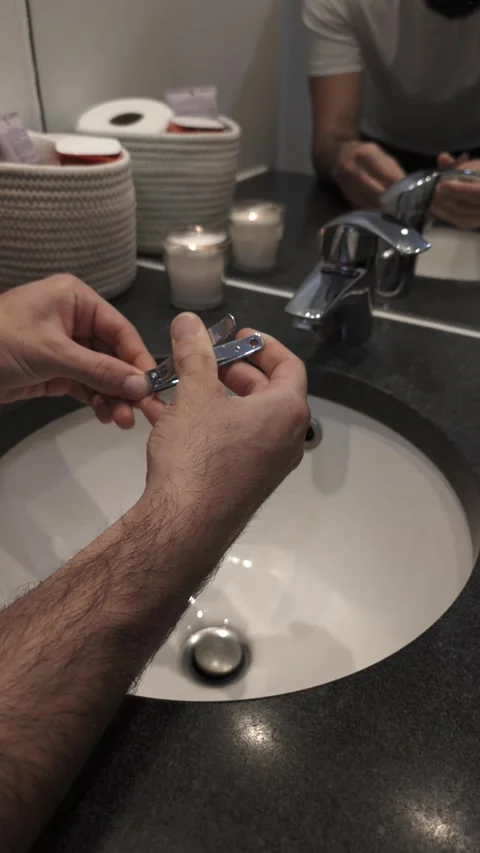 Close-up of man's hands trimming fingernails with clipper in bathroom Video stock 335638132