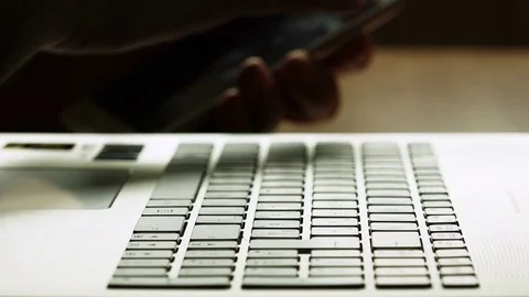 Close Up Of A man's Hands Typing On Laptop Keyboard and using smartphone Stock Footage 74413660