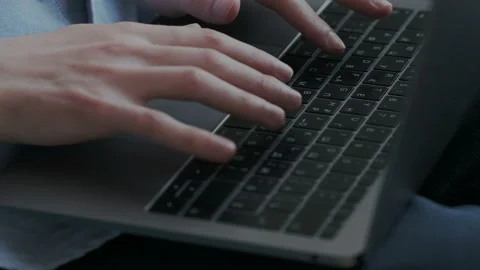 Close up of mans hands typing on laptop keyboard at office. Male fingers press Stock Footage
