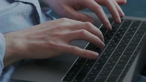 Close up of mans hands typing on laptop. The author writes an article at home or Stock Footage 107811797