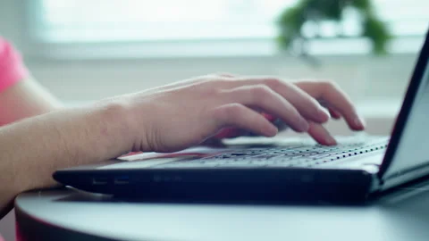 Close-up of a man's hands typing on a laptop keyboard at a desk Stock Footage 306234898