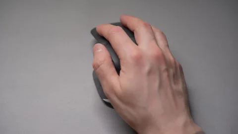 Close up man's hands use a wireless computer mouse. Click on the gray wireless Stock Footage 307703139