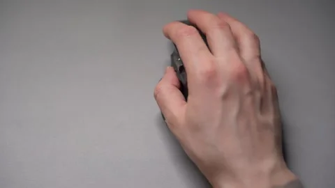 Close up man's hands use a wireless computer mouse. Click on the gray wireless Stock Footage 307703148