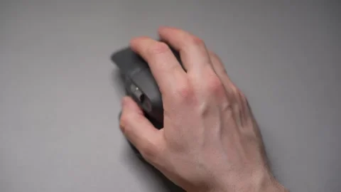 Close up man's hands use a wireless computer mouse. Click on the gray wireless Stock Footage 307703299