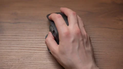 Close up man's hands use a wireless computer mouse. Click on the gray wireless Stock Footage 307703343