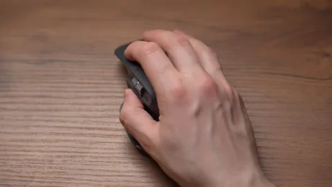Close up man's hands use a wireless computer mouse. Click on the gray wireless Stock Footage 307703387