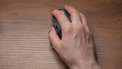 Close up man's hands use a wireless computer mouse. Click on the gray wireless Stock Footage 307703850