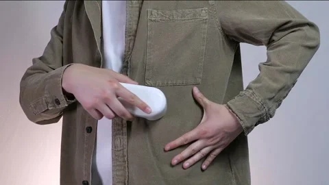 Close-up of a mans hands using a fabric shaver to remove pilling from clothing Stock Footage 314424574