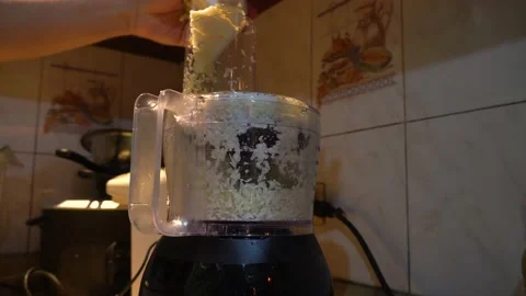 Close up of man's hands using a food processor to shred a cabbage vegetable Stock Footage 146003953