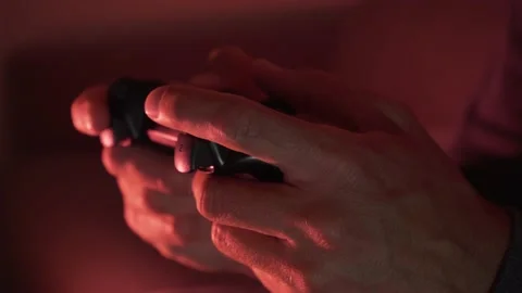 Close-up of a man's hands using joystick playing video games in a dark room Stock Footage 193660038