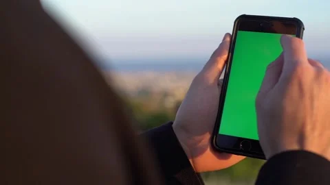 Close-up of man's hands using mobile phone with green screen Stock Footage 133375597