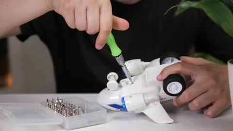 Close-up of a mans hands using a screwdriver to expertly replace the battery in Stock Footage 315175411