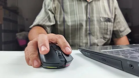 Close-up of a man's hands using a wireless computer mouse on a desk, spinni.. Stock Footage 338321806