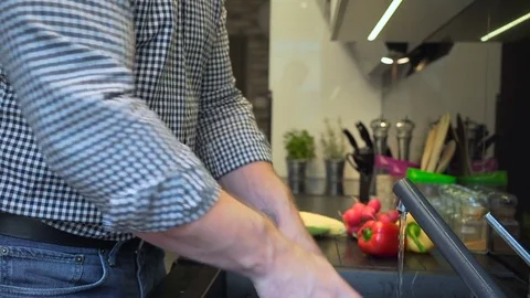 Close up on man's hands washing corn on the cob. Slider shot. Vídeo Stock 70574049