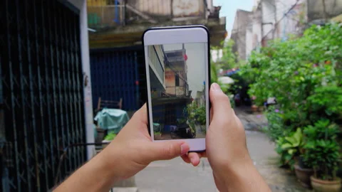 Close up of mans hands while walking and taking photo or video of Bangkok alley Stock Footage 201095815