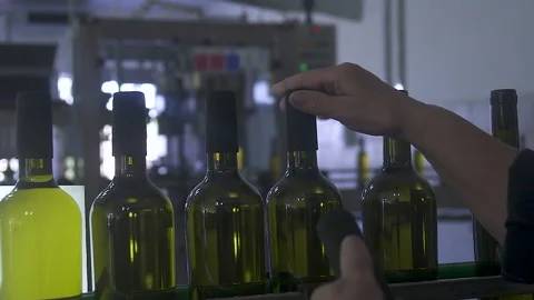 Close-up of a man's hands Wine Fit Caps On to Sealed Bottles On An Assembly Line Stock-Footage 155454128