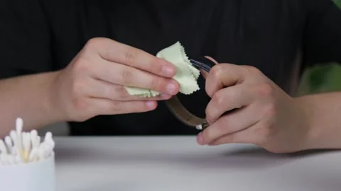 A Close-up of a mans hands wiping a leather strap wristwatch with a special Stock Footage 314091741
