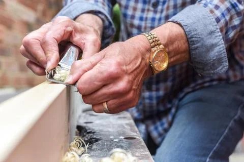 Close up of mans hands working with a plane on wooden plank Stock Photos