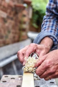 Close up of mans hands working with a plane on wooden plank Stock Photos