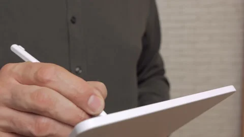 Close-up of a man's hands writing on the touch screen of a tablet using a stylus Stock Footage 165386271