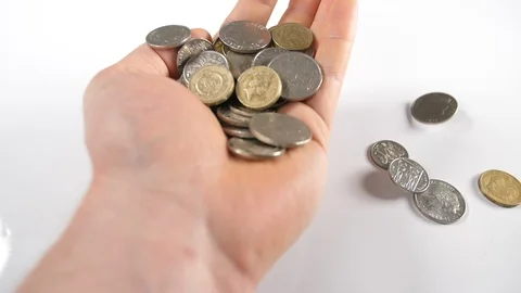 Close up of a mans holding and grasping gold and silver coins falling from above Stock Footage 89186846