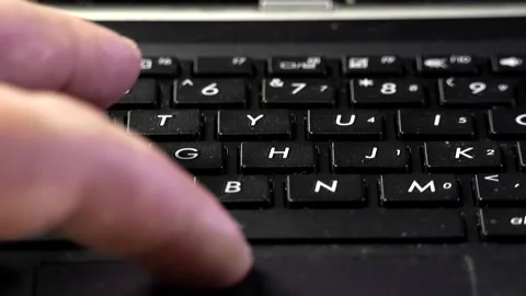 Close-up of a man's left hand fingers typing on a black laptop keyboard Stock Footage 342256550
