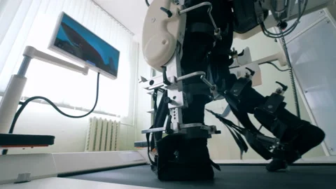 Close up of man's legs in bonds of a training machine during walking exercises Stock Footage 91965022