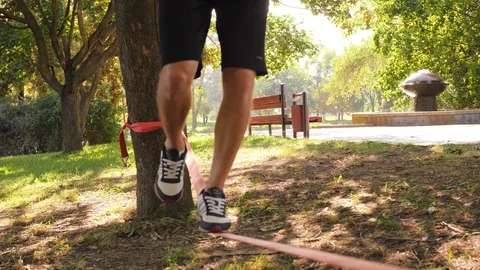 Close-up of man's legs walking on the slackline 4K slow mo footage Stock Footage 99140993