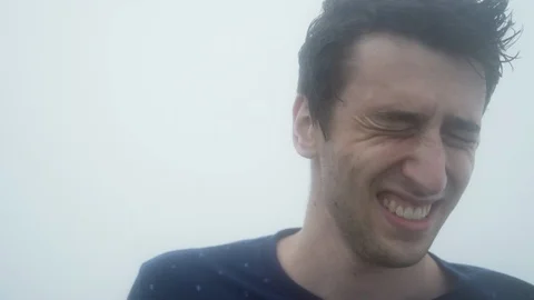 Close up of a mans reaction as he struggles with winds in the midst of a 스톡 동영상 94120449