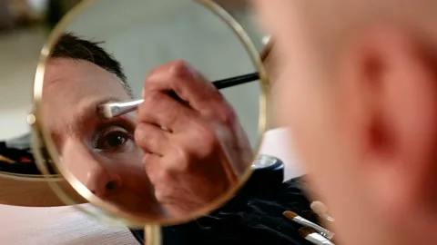 Close-up of man's reflection in the mirror. Attractive guy  applying eye shadows Stock Footage 161833593