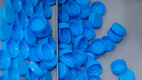 Close up: many blue plastic bottle caps moving on conveyor belt at factory Vidéo 163810843