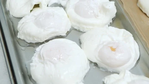 Close-up of many cooked poached eggs on a tray. Preparing ingredients for Stock Footage 150971243