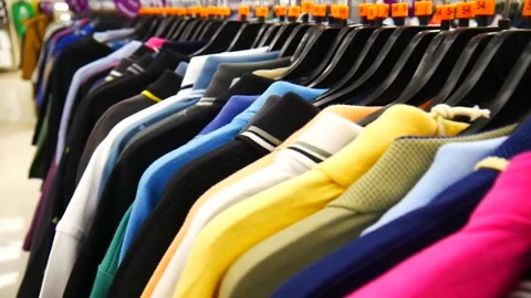 Close-up of many different polo t-shirts hanging in a clothing store Stock Footage 276643624
