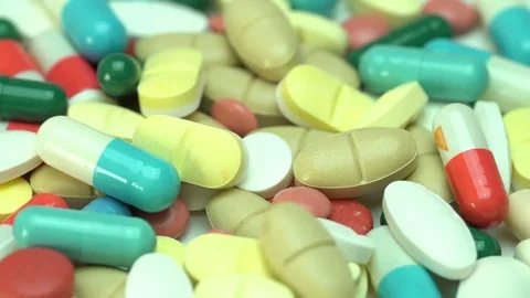 Close-up of many different turning pills Stock Footage 82145492